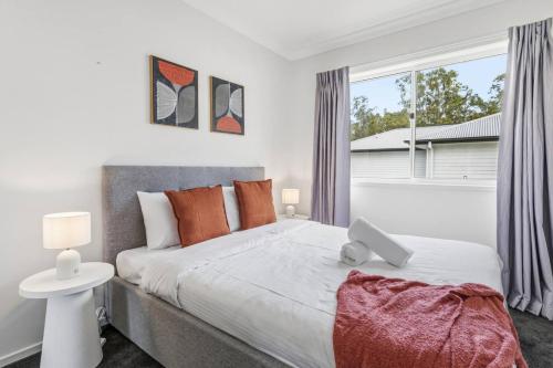 Modern Family Home in Peaceful Pallara 4BR Comfort في Algester: غرفة نوم بسرير كبير ونافذة