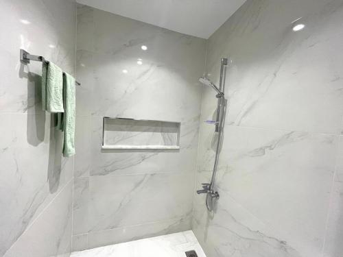 Un baño blanco con ducha y lavabo. en Luxurious condo with patio and terrace, en Alhucemas