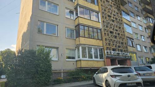 a white car parked in front of a building at Kambarių nuoma Kaune Taikos pr in Kaunas