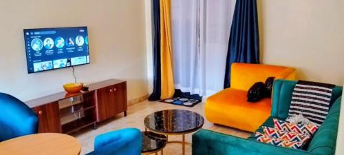 Turquoise Haven في نيروبي: غرفة معيشة مع أريكة وتلفزيون بشاشة مسطحة