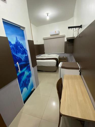 ein kleines Zimmer mit einem Bett und einem Tisch in der Unterkunft Mais Hotel Express in São Luís