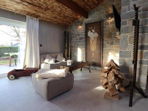 a living room with a couch and a stone wall at Chez Brigitte in Durbuy