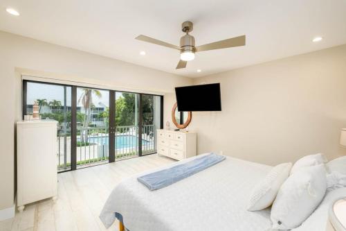 a bedroom with a bed and a flat screen tv at Beautiful Key Largo Escape Pool, Tennis & Marina in Key Largo