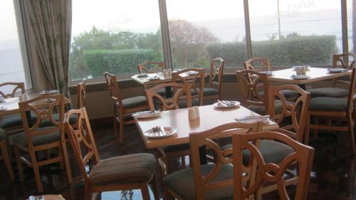 a dining room with tables and chairs and a window at La Mercy Beach Hotel in La Mercy