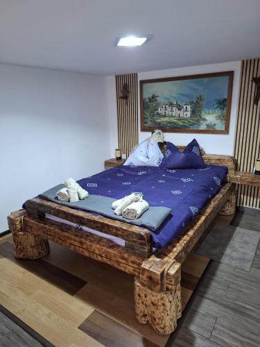 a large wooden bed with a teddy bear laying on it at AMA house in Alba Iulia