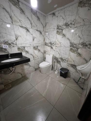a bathroom with a toilet and a sink at Chácara Tubaras in Uberlândia