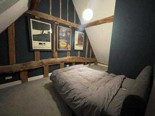a bedroom with a bed and pictures on the wall at Entertainment Packed 3BDR Barn at Stevenage in Shephall