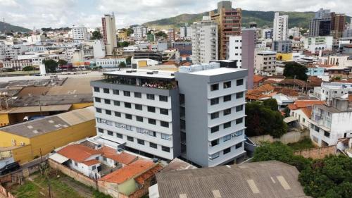 mit Blick auf eine Stadt in einem weißen Gebäude in der Unterkunft Studios super modernos, completos e equipados no centro de Pará de Minas in Pará de Minas