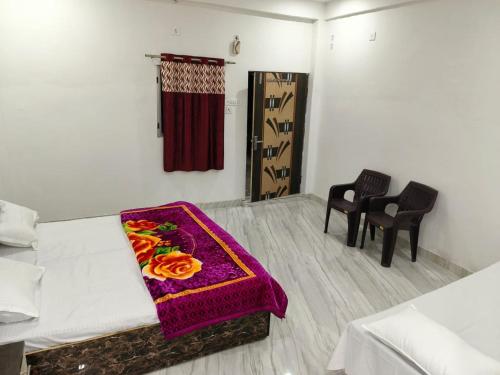 a room with a bed with a purple blanket on it at Manglam House in Ayodhya