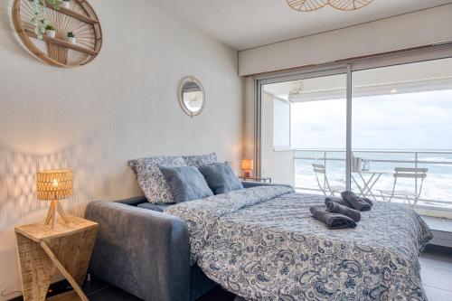 een slaapkamer met een bed met uitzicht op de oceaan bij Premium Ocean View Studio, Balcony & Pool in Les Sables-dʼOlonne
