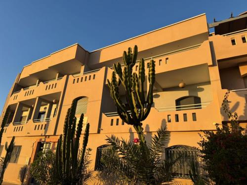 ein Gebäude mit einer Palme davor in der Unterkunft Mirleft Horizon Suites in Mirleft