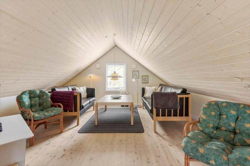 ein Wohnzimmer mit Dachterrasse, Stühlen und einem Tisch in der Unterkunft 3690 Nexø - Hovedgade 2 in Snogebæk