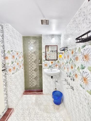 a bathroom with a sink and flowers on the wall at Prasads Homestay in Gaya