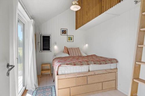 a small bedroom with a bed and a window at 6798-Allinge-Aeblebakken-9 in Allinge