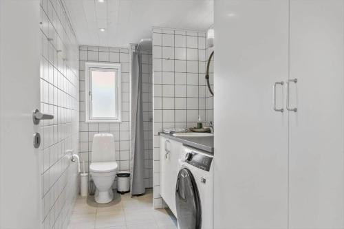 a bathroom with a toilet sink and a washing machine at 6798-Allinge-Aeblebakken-9 in Allinge