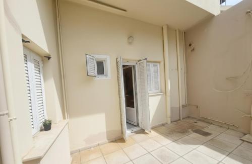 a hallway with white walls and shuttered windows at Characterful 2-Bed Home in Peaceful Town Near Agios Nikolaos in Neápolis