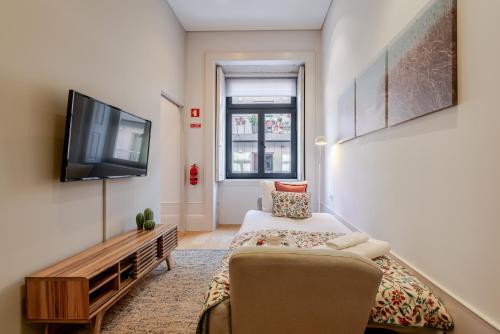 a small room with a bed and a tv at Host Wise - Modern Stuning Flat w Prime Location in Porto