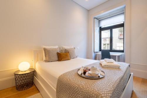 a bedroom with a bed with a tray on it at Host Wise - Modern Stuning Flat w Prime Location in Porto