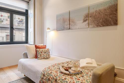 a bedroom with a bed and a table with a plate on it at Host Wise - Modern Stuning Flat w Prime Location in Porto