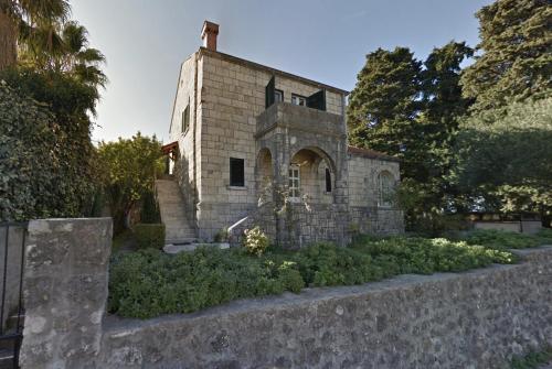 un antiguo edificio de piedra con un jardín delante en Old Villa in Dubrovnik, en Dubrovnik