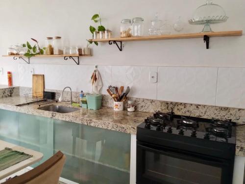 eine Küche mit einem schwarzen Herd und einer Spüle in der Unterkunft Casa Vieira in Piranhas