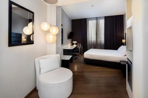 a hotel room with a bed and a chair at Holiday Inn Genoa City by IHG in Genoa