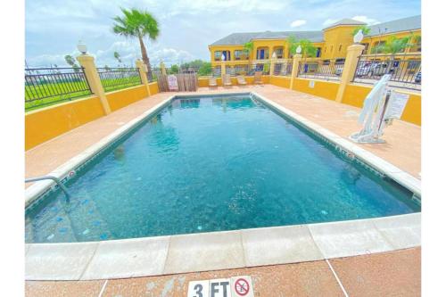 a swimming pool with blue water in front of a house at Weslaco Inn by Capital O Near Mercedes in Weslaco