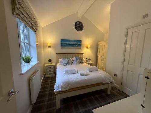 a bedroom with a bed and a window at Mariners, The Bay, 2 bedrooms with ensuites, parking nearby, 1 medium or 2 small dogs welcome in Filey