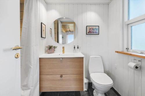 a bathroom with a sink and a toilet and a mirror at G421-Lemvig-Gyvelvej-21 in Lemvig