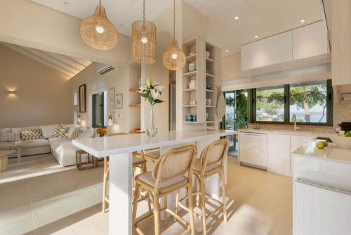 una cocina con una gran isla blanca con sillas en Villa Levantina, en Porto Heli