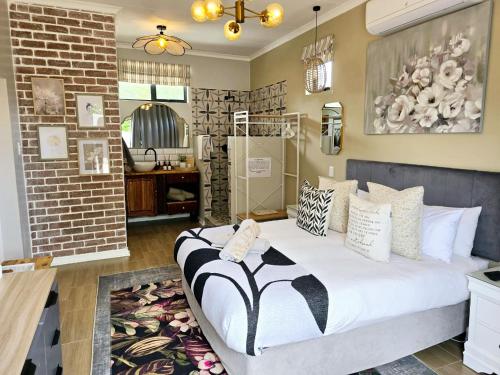 a large bed in a room with a brick wall at Karoovlaktes in Prieska