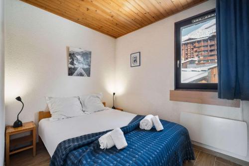 a bedroom with a bed with towels on it at Ski-in Chalet-Style View Flat - Résidence les Eterlous in Val Thorens