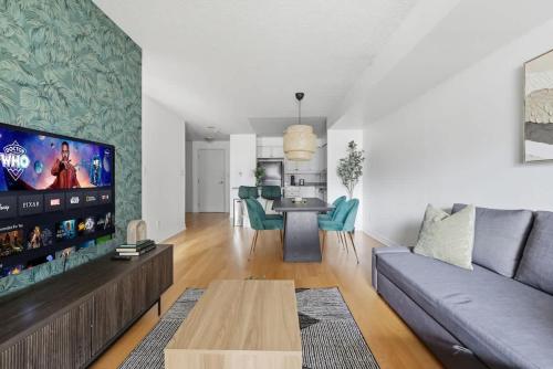 Tropical Designer King Suite - Sleeps 5 - Parking في ميسيساوغا: غرفة معيشة مع أريكة وتلفزيون بشاشة مسطحة