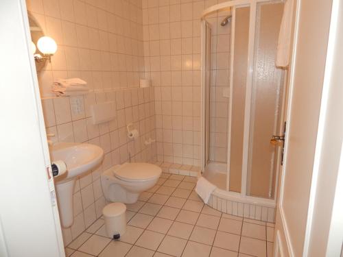 a white bathroom with a toilet and a shower at Koll´s Gasthof in Weddingstedt
