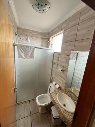 a bathroom with a toilet and a sink and a shower at Hotel Inter Alexandria in Cândido Mota