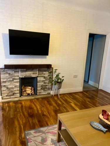 a living room with a fireplace with a flat screen tv at Two bed Bungalow in Huddersfield