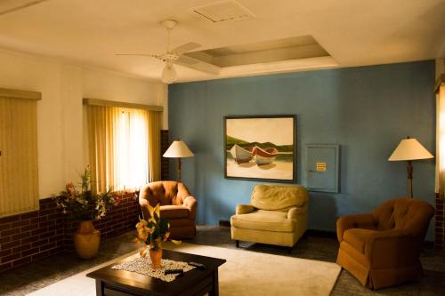 a living room with two chairs and a blue wall at Hotel Águas Vivas in Caraguatatuba