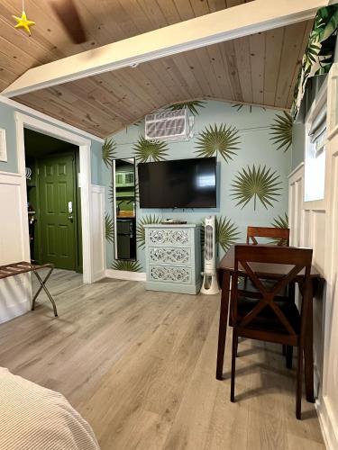 a bedroom with a tv on the wall and a table at Palm Paradise Retreat in St. Petersburg