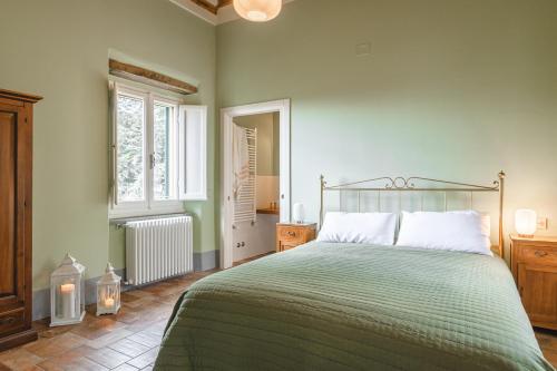 a bedroom with a bed with a green bedspread at Dimora Vecchio Duomo - Together in Tuscany in Cortona
