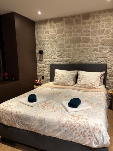 ein Schlafzimmer mit einem Bett mit zwei Hüten darauf in der Unterkunft Au Plaisir Vosgien in Raon-lʼÉtape