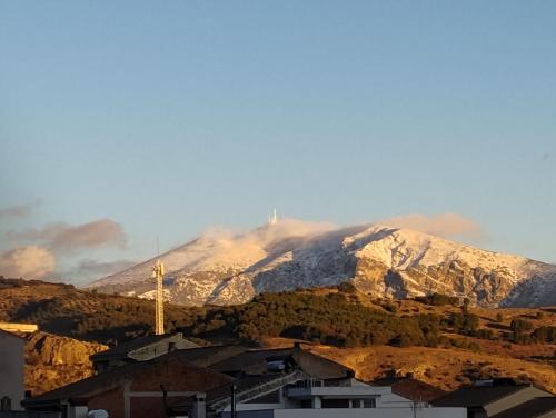 a mountain in the distance with a building in front at Alojamiento rural casa cueva abuelo Miguel in Pegalajar