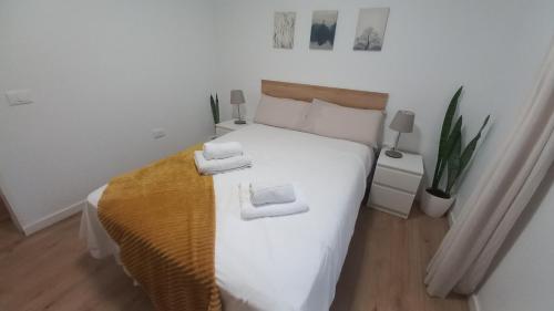 ein Schlafzimmer mit einem weißen Bett mit zwei Handtüchern darauf in der Unterkunft Villa Star in Agaete