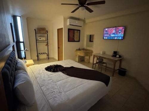 Un dormitorio con una cama con ventilador de techo. en Hotel Grand Lion, en Torreón