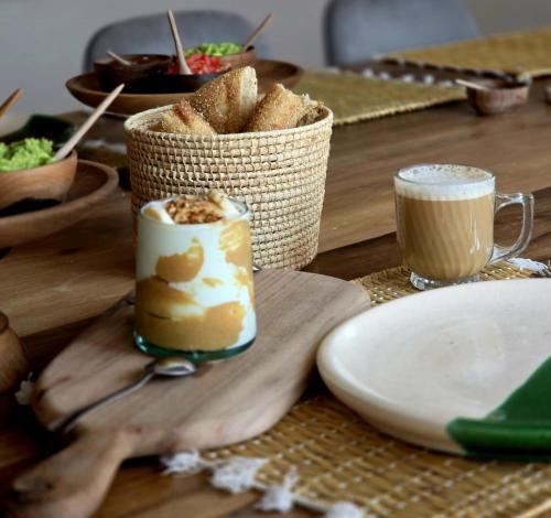 a wooden table with two cups of coffee and bread at Tempo B&B in Essaouira