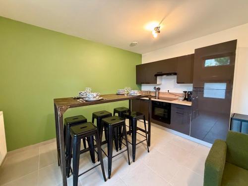 Le Jupiter, Centre ville, Parking Privé في بورجوا: مطبخ بجدران خضراء وكاونتر مع الكراسي