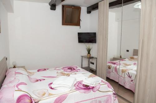 a bedroom with two beds with pink flowers on them at Casa Piazza Garibaldi in Sulmona