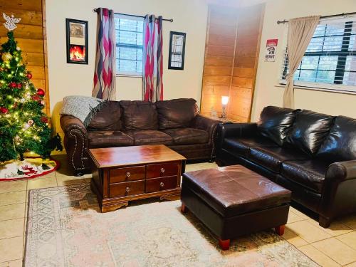 a living room with a christmas tree and a leather couch at Smoky Mountain Cabin with HOTTUB in Seymour
