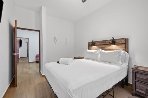 a bedroom with a large white bed and a mirror at Playas de Tijuana in Tijuana