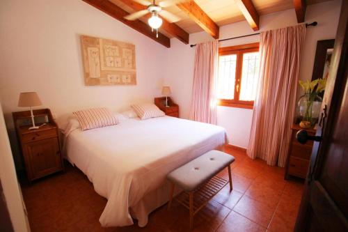 a bedroom with a large white bed and a window at Casa Eva in Fornalutx