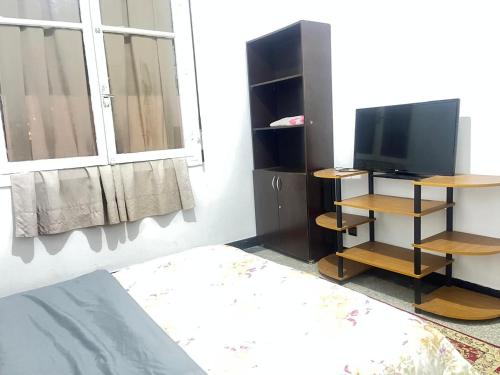 a bedroom with a tv and a bed and a window at Agdal apart in Rabat